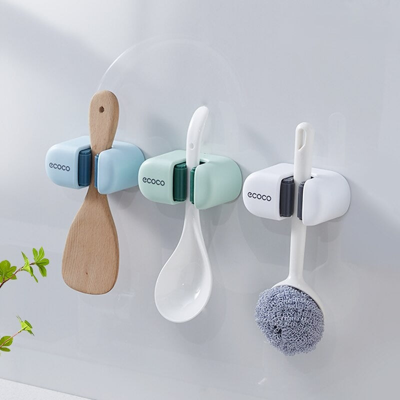 Close-up of a white Ecoco wall-mounted mop holder with a secure locking mechanism for organizing cleaning tools.