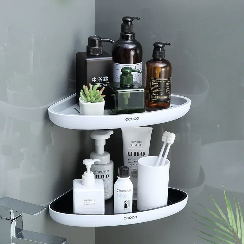 Two-tier Ecoco wall-mounted corner shelf holding bathroom essentials, including bottles, toothbrushes, and a small plant.