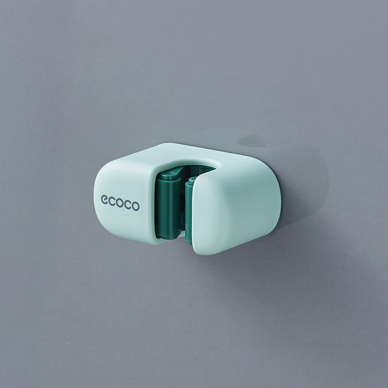 Minimalist green Ecoco holder mounted on a wall, securely holding a mop handle for easy access and organization.

