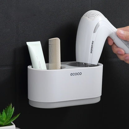 White wall-mounted Ecoco holder with soft pink accents, featuring slots for a hairdryer, brushes, and beauty essentials for a neat setup.