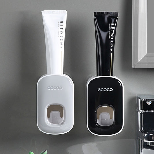 Sleek black Ecoco toothpaste dispenser mounted on a bathroom wall for convenient, mess-free toothpaste dispensing.