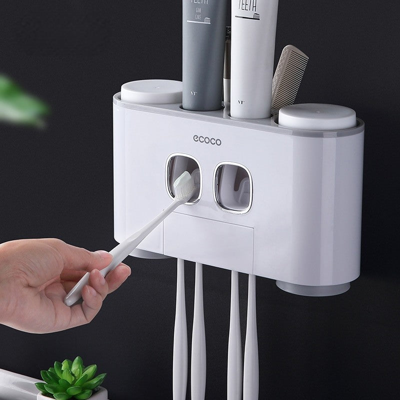 White Ecoco dual toothpaste dispenser with toothbrush holders and storage cups for organized bathroom essentials.

