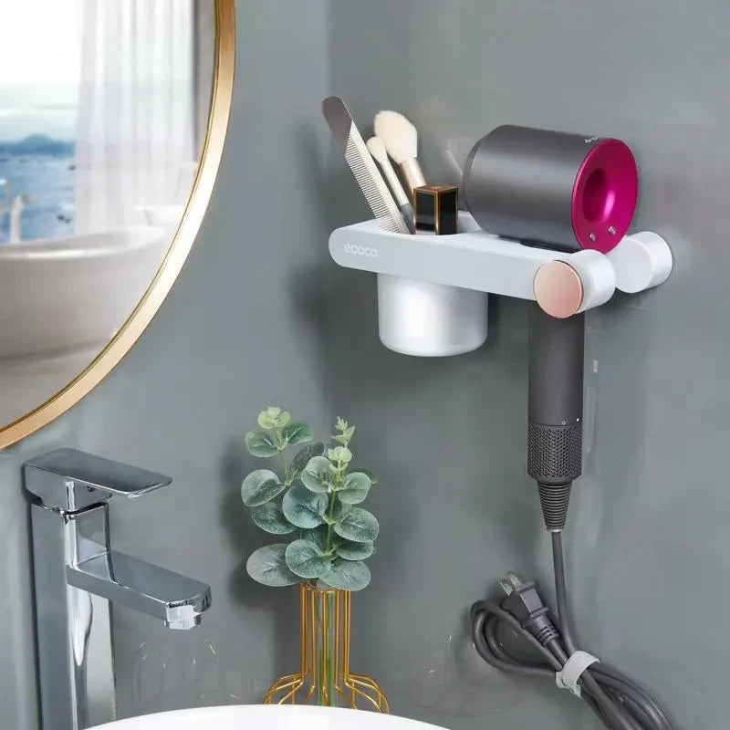 Wall-mounted holder designed for secure storage of hair dryers, featuring a magnetic base and an extra cup for small accessories.

