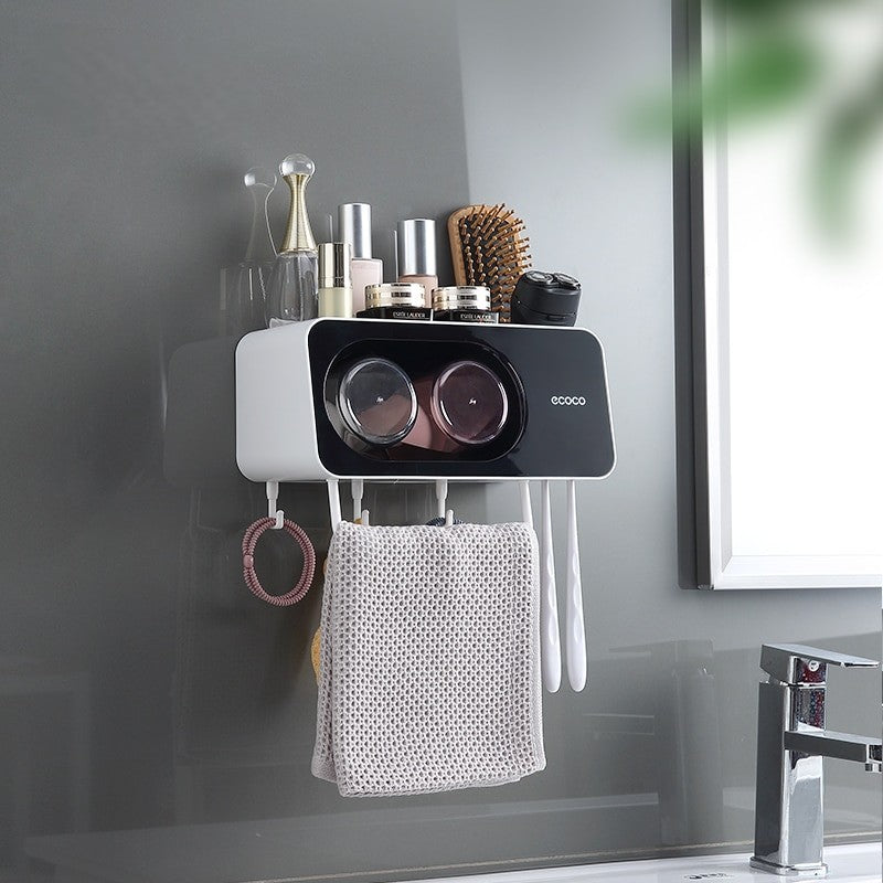 ecoco Wall-mounted multi-functional kitchen storage rack with four integrated cups, a top shelf for toiletries or kitchen essentials, hanging hooks for towels and accessories, and a sleek modern design.

