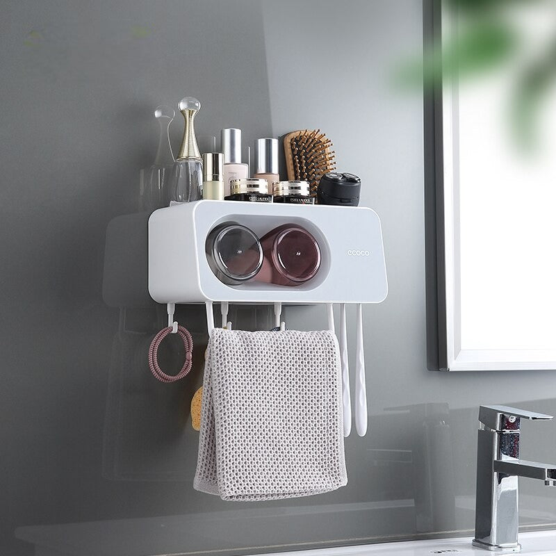 ecoco Wall-mounted multi-functional kitchen storage rack with four integrated cups, a top shelf for toiletries or kitchen essentials, hanging hooks for towels and accessories, and a sleek modern design.

