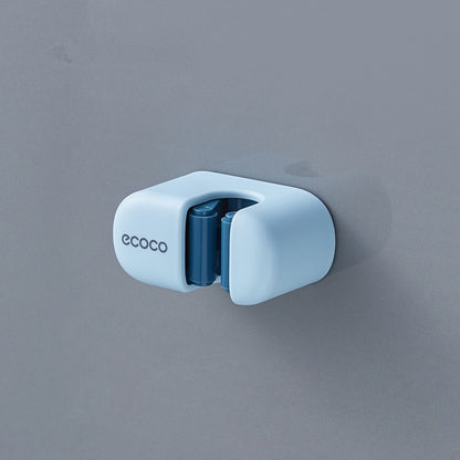 Minimalist baby blue Ecoco holder mounted on a wall, securely holding a mop handle for easy access and organization.